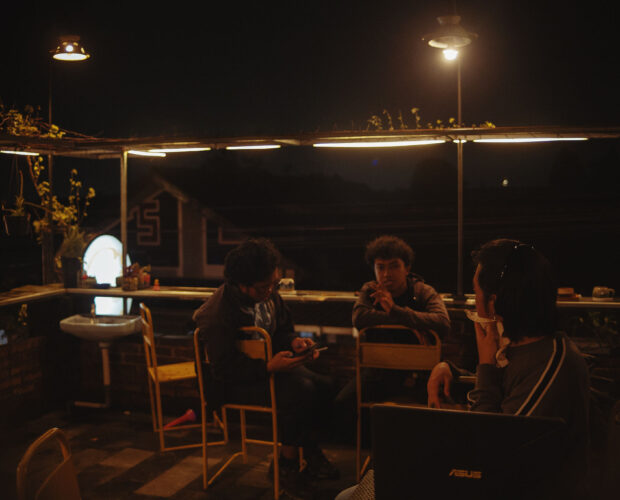 Suasana meja kopi di malam hari di Dongeng Kopi, percakapan pelanggan tentang kabar kekerasan terhadap aktivis pro demokrasi.