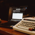 Sebuah mesin ketik tua merek Royal bersanding dengan laptop tipis di atas meja komunal Dongeng Kopi Dalangan.
