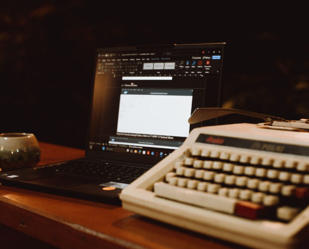 Sebuah mesin ketik tua merek Royal bersanding dengan laptop tipis di atas meja komunal Dongeng Kopi Dalangan.